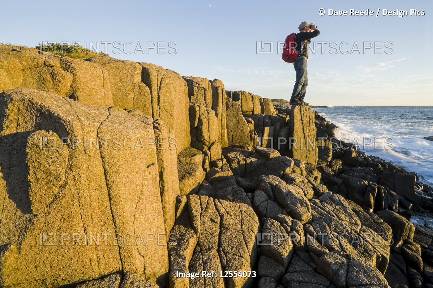 Hiker on basalt rock cliffs, Dartmouth Point, Bay of Fundy; Long Island,Nova ...