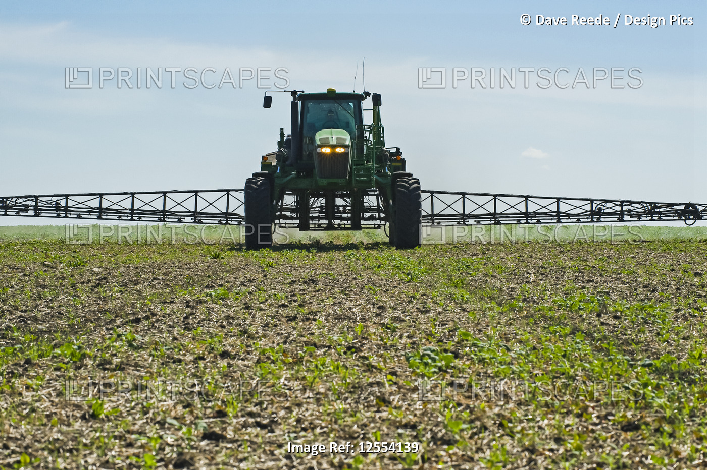 A high clearance sprayer gives a ground chemical application of herbicide to ...