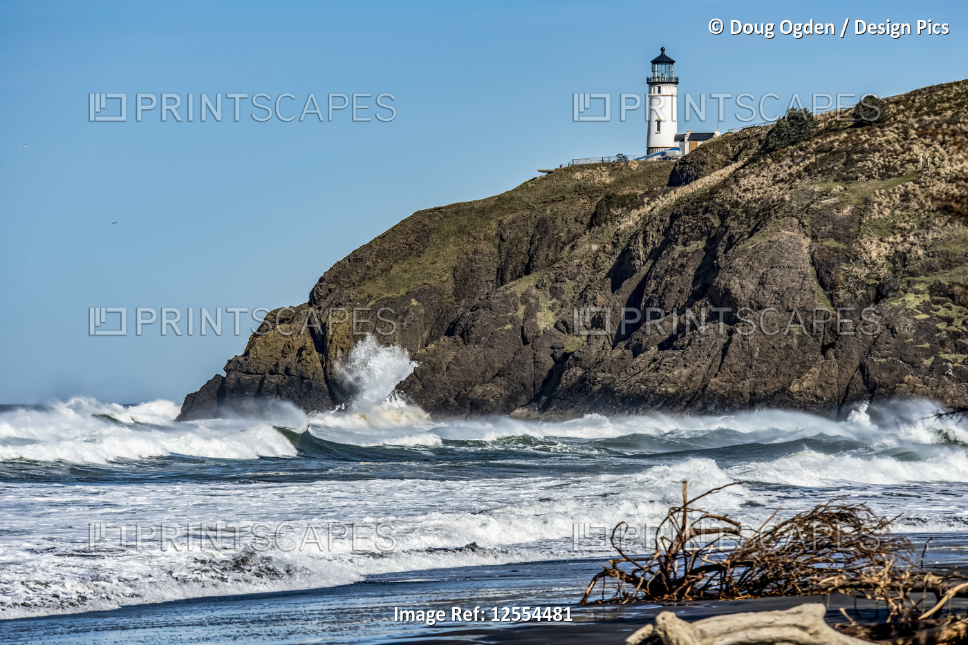 Waves crash on the rocks below the Cape Disappointment North Head Lighthouse ...