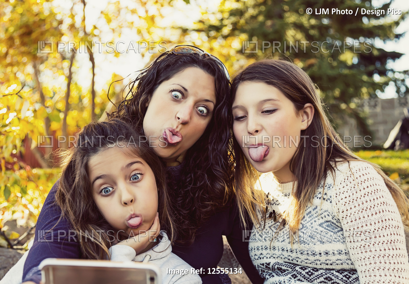 A mom and her two daughters taking a self-portrait while resting during a ...