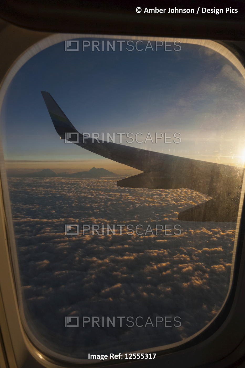 View of Denali and Alaska Range from Alaska Airlines jet at sunset with clouds; ...