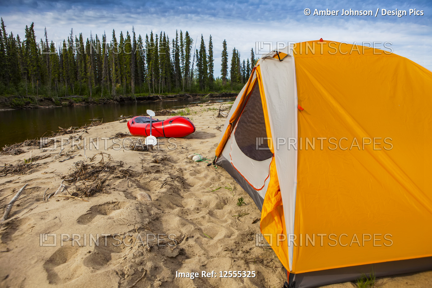 Tent and packraft on sandy beach on the Charley River on a sunny da ...
