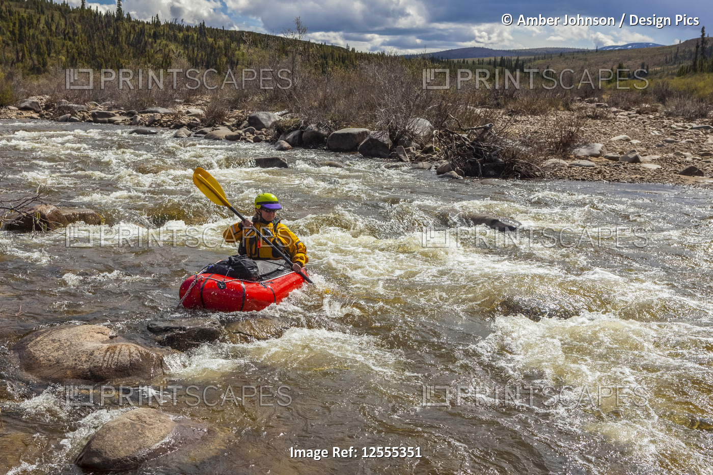 Woman packrafter negotiating a technical rapid on the tributary of the Charley ...