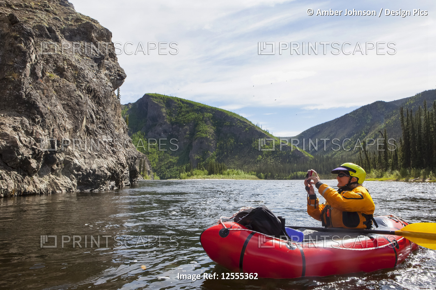 Woman photographing from her Packrafting on the Charley River in summertime, ...