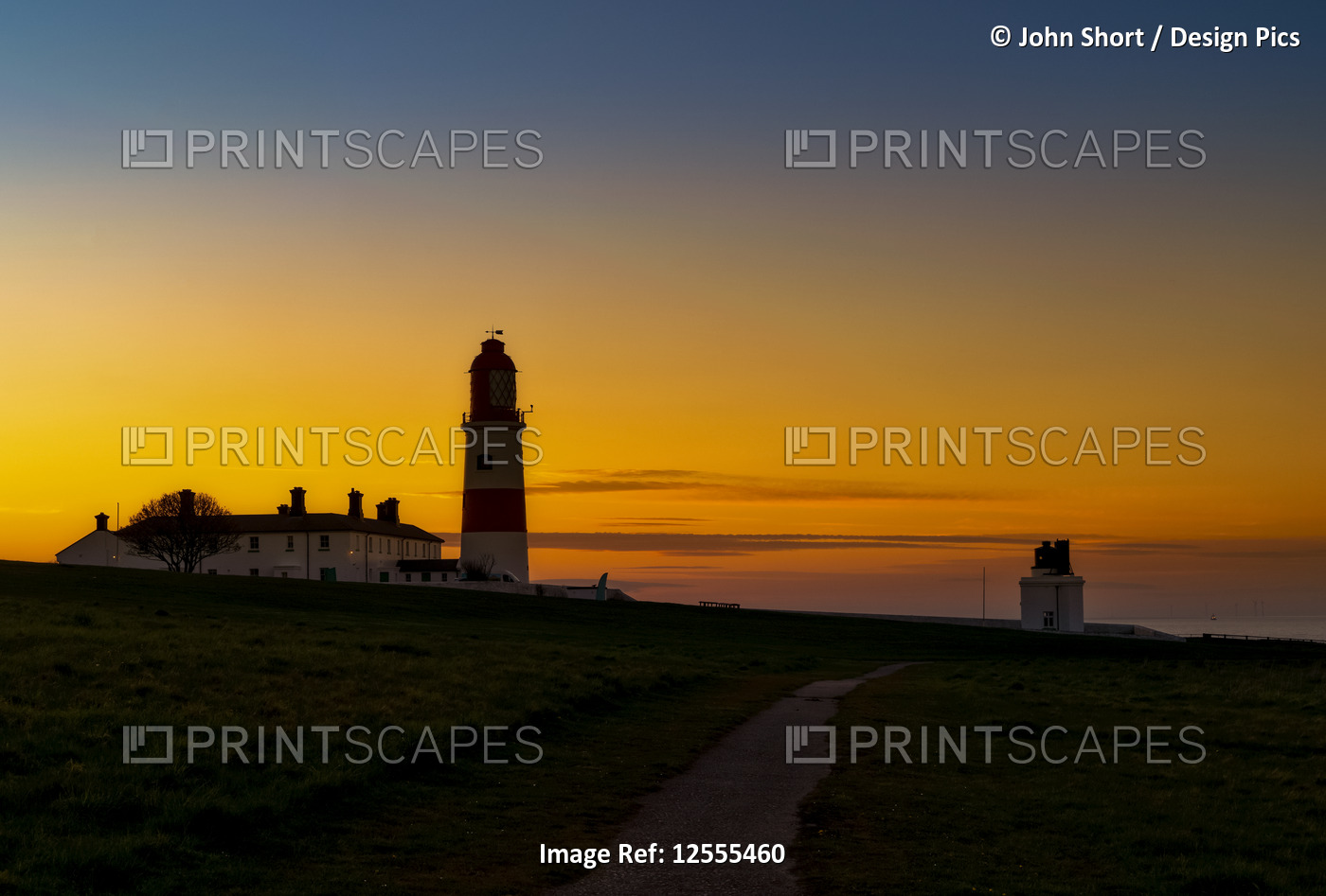 Souter Lighthouse at sunset with glowing orange and gold sunset; South Shields, ...