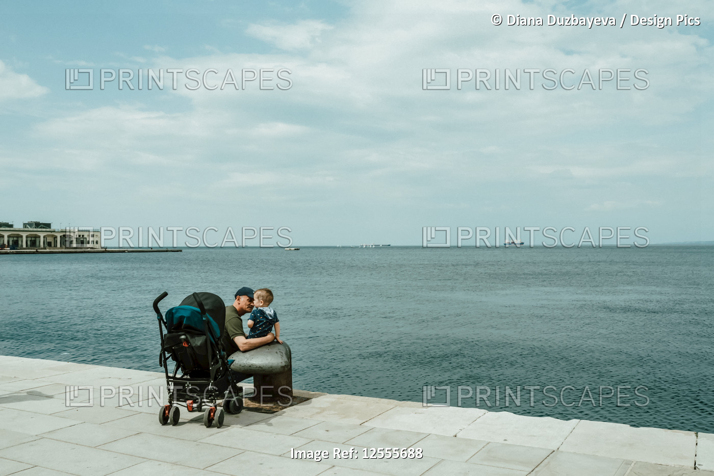 Father and baby boy on a waterfront promenade on the Adriatic Sea; Italy