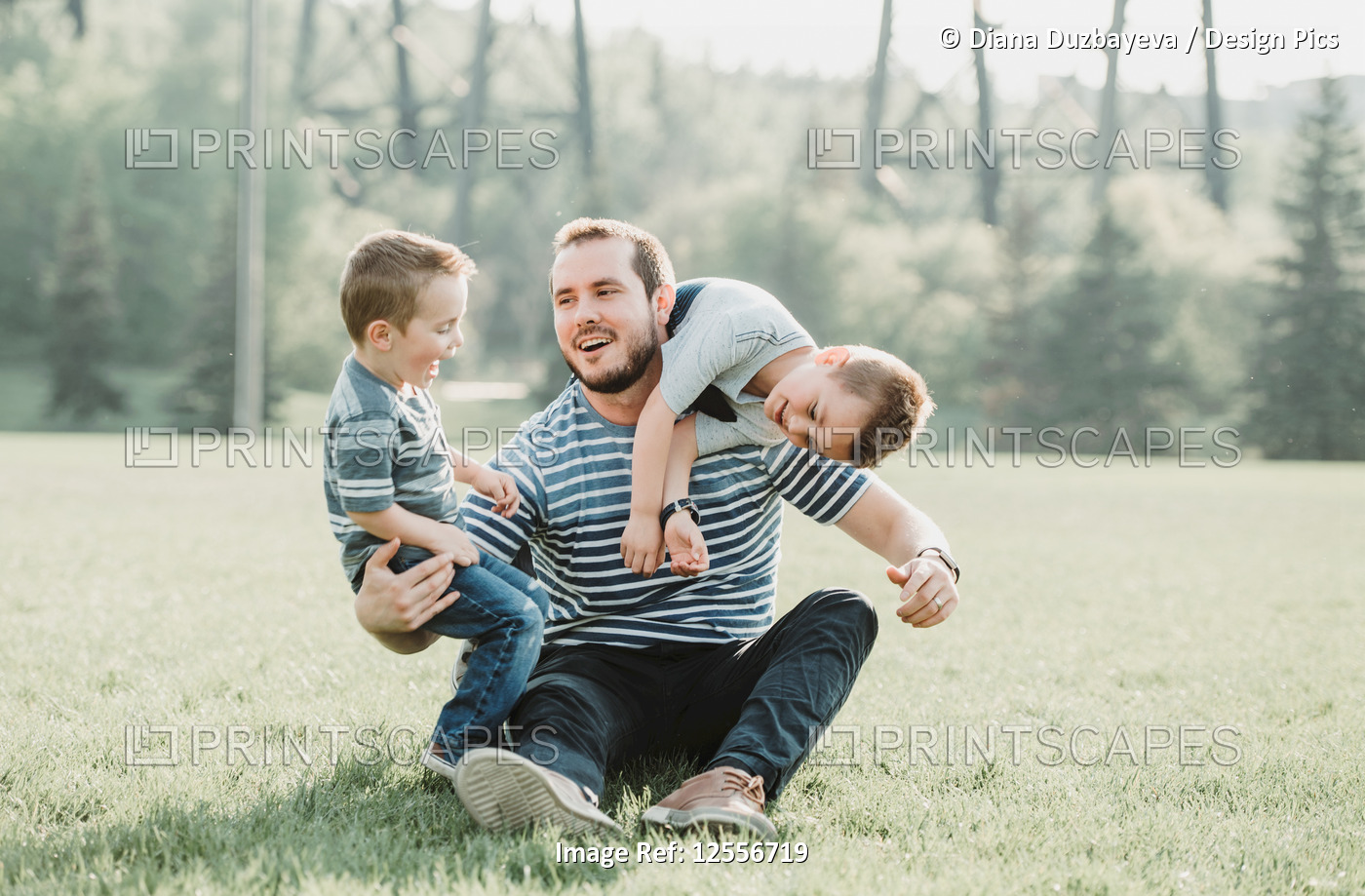 Father with young sons playing in a park; Edmonton, Alberta, Canada