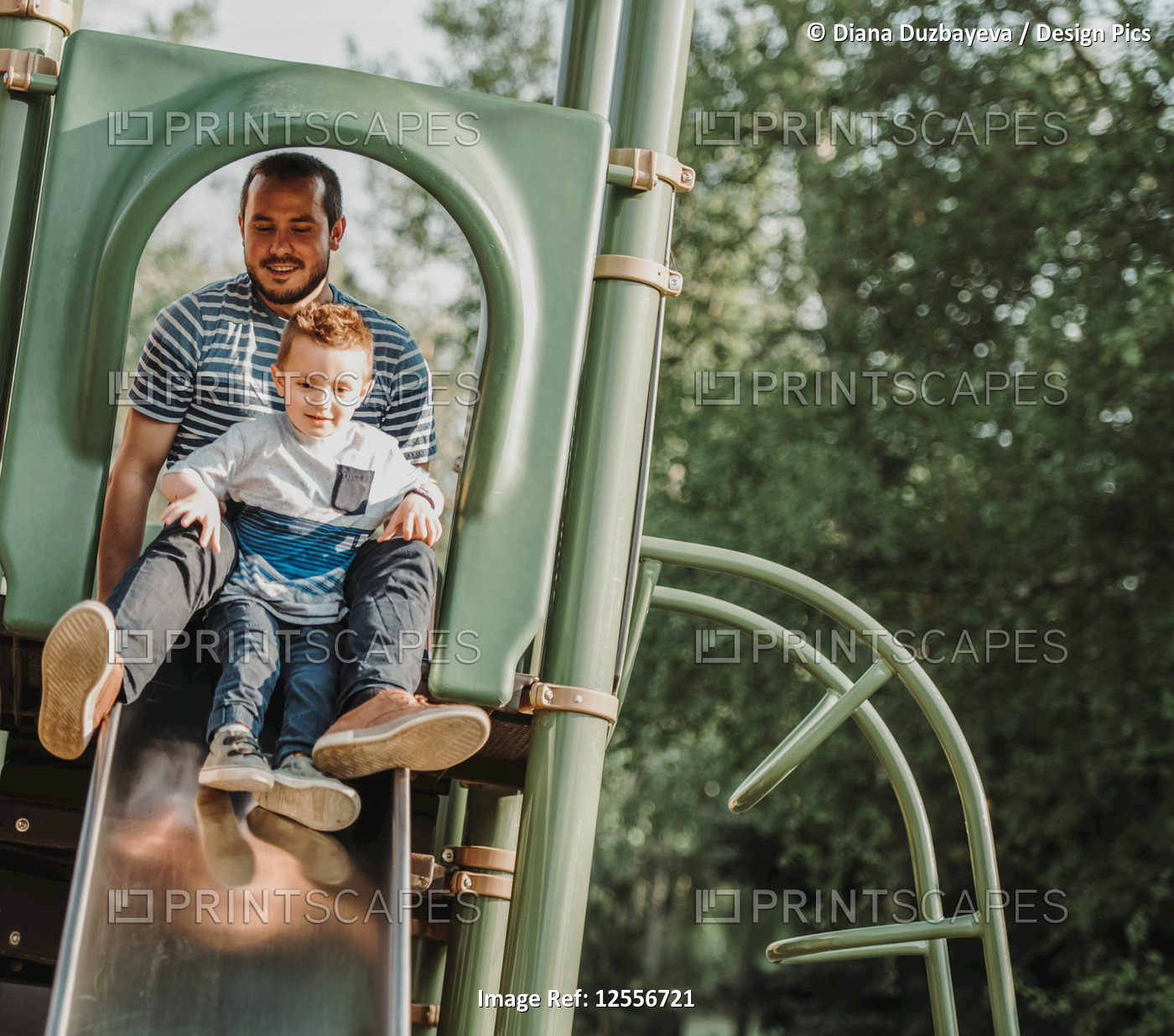 Father on a slide with young son; Edmonton, Alberta, Canada