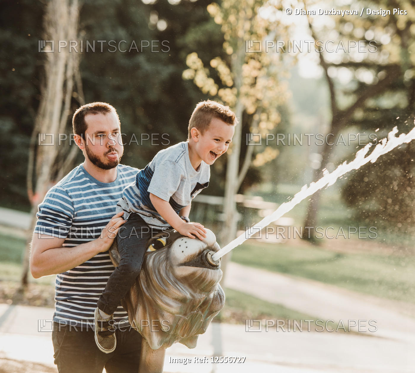 Father and young son at spray park; Edmonton, Alberta, Canada