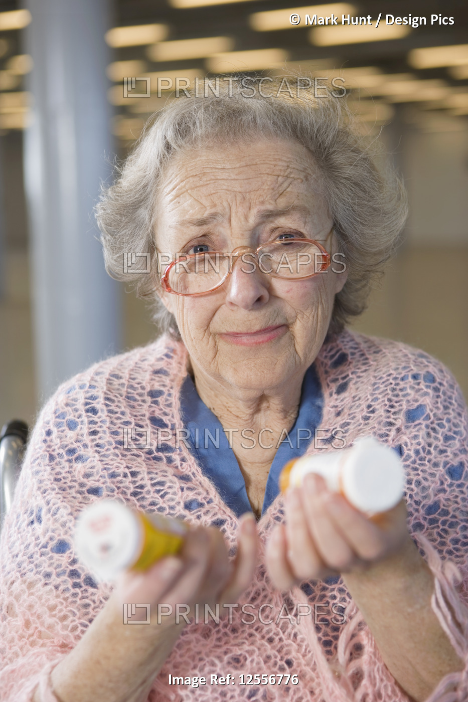 View of a senior woman holding medicines in hands.