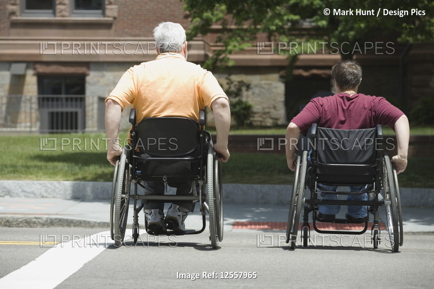 Rear view of a mature man with Muscular Dystrophy and a young woman crossing a ...