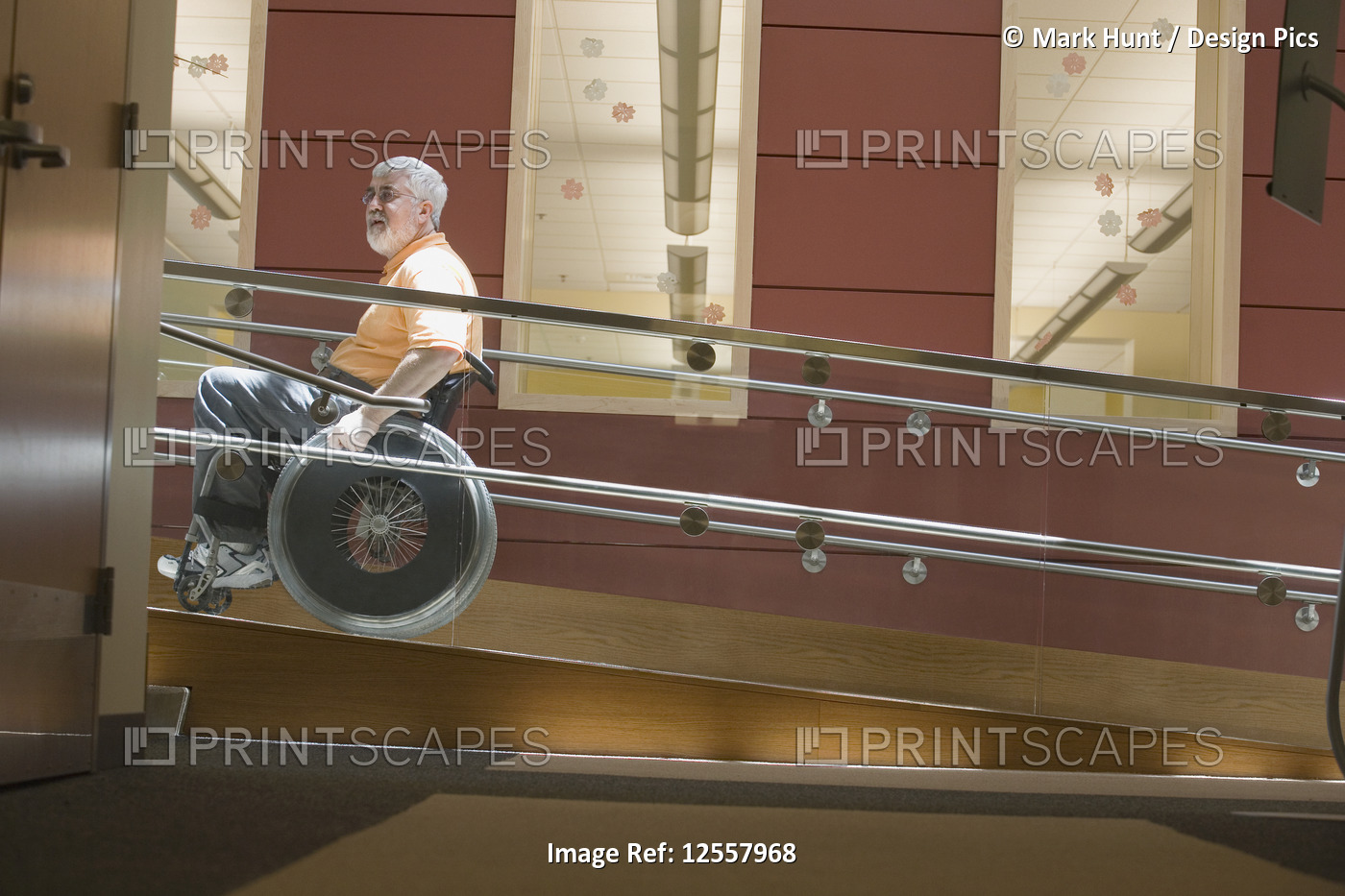 Side profile of a mature man with Muscular Dystrophy sitting in a wheelchair on ...