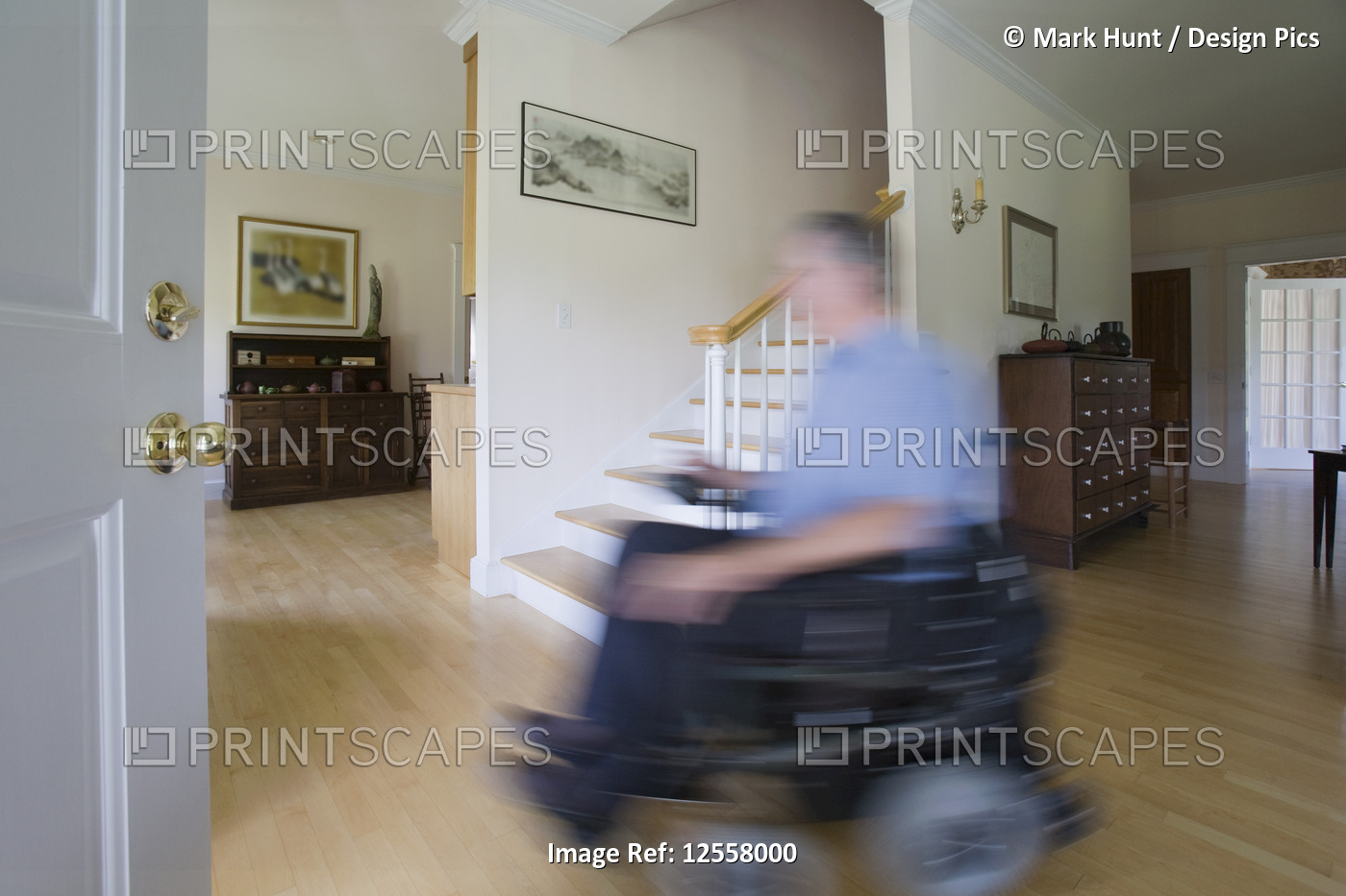 Man with Polio on electric wheelchair at home, blurred in motion