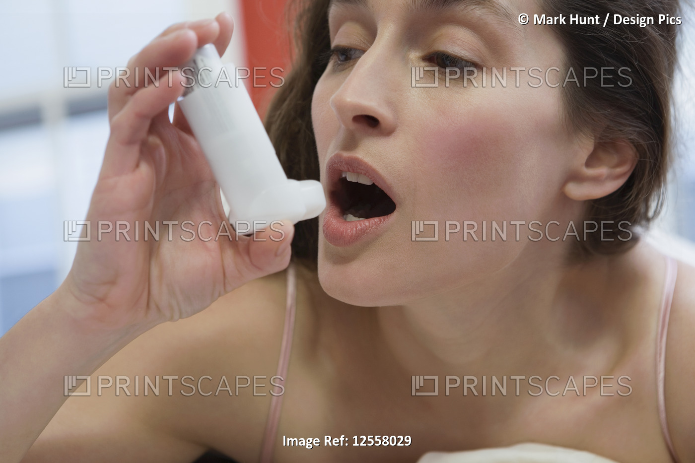 Close-up of a mid adult woman using an asthma inhaler