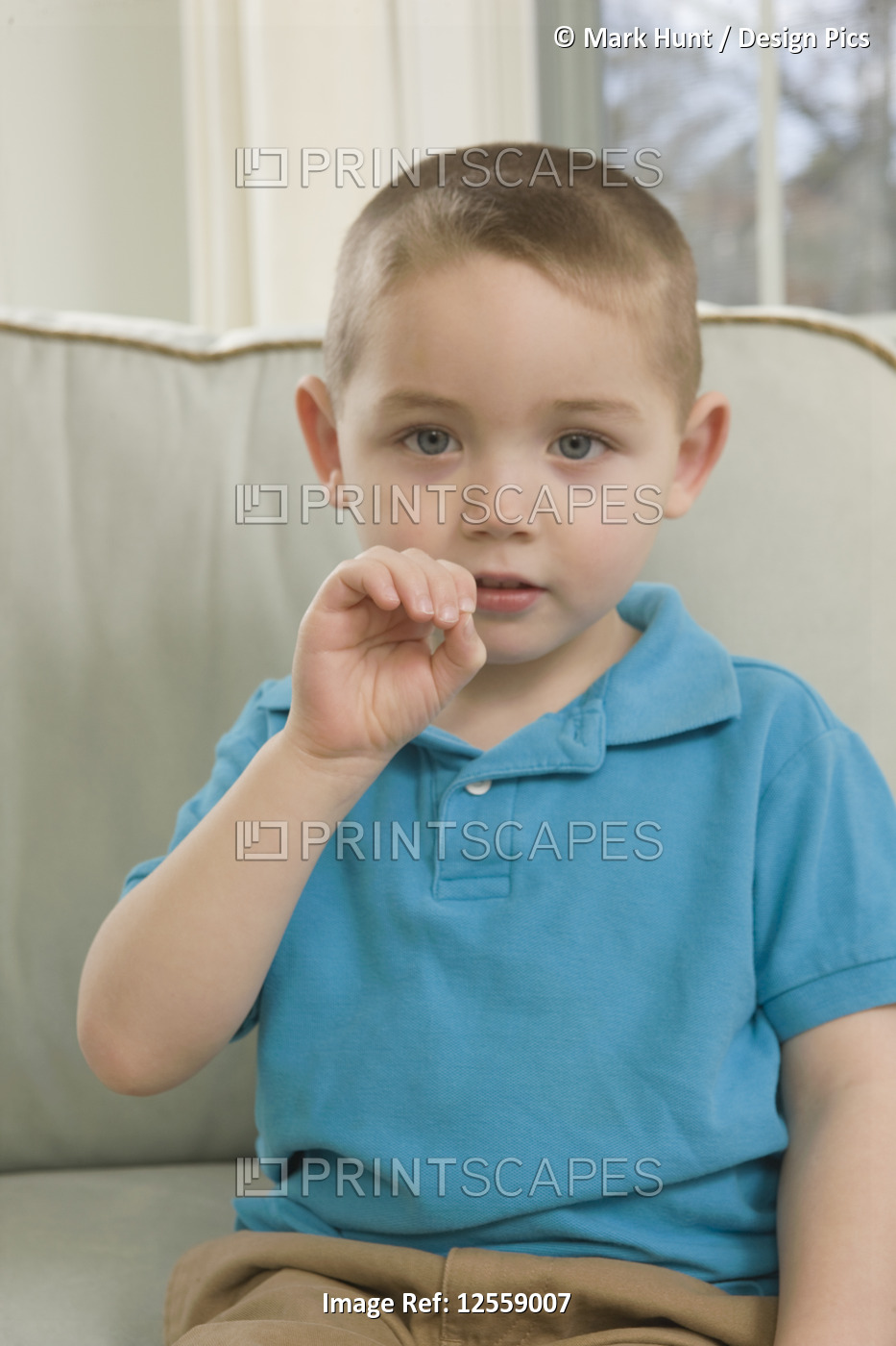 Boy signing the letter 'O' in American sign language