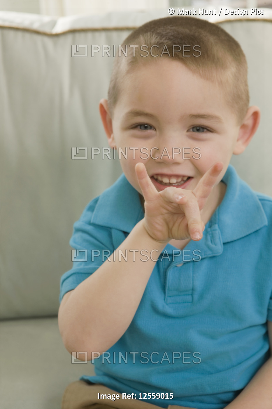 Boy signing the number '8' in American sign language