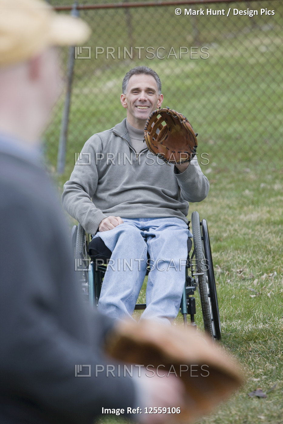 Disabled man playing baseball with his son