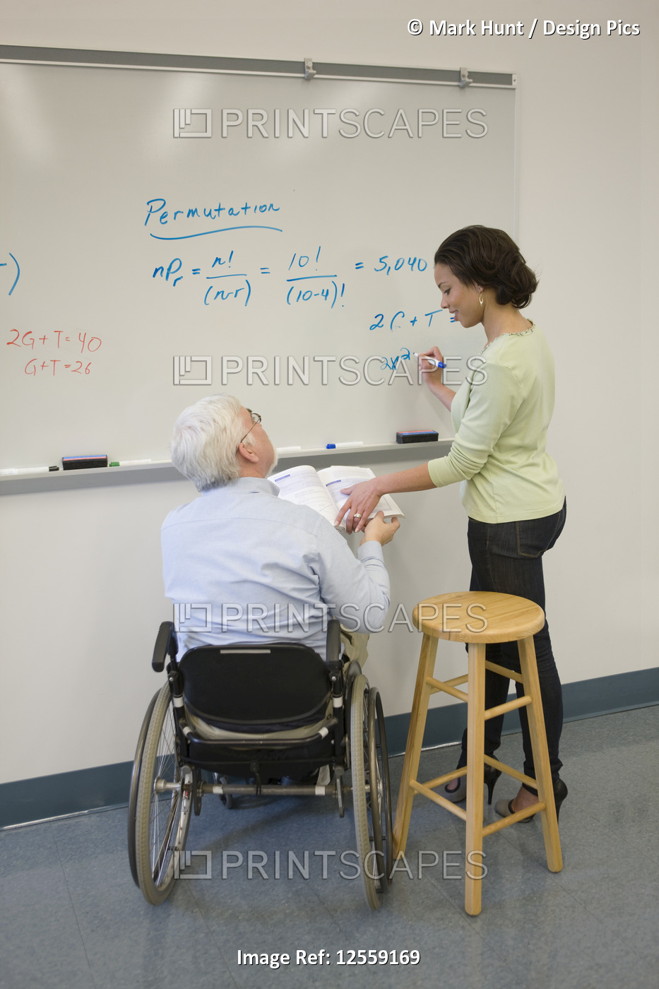 University professor with Muscular Dystrophy teaching his student in a classroom