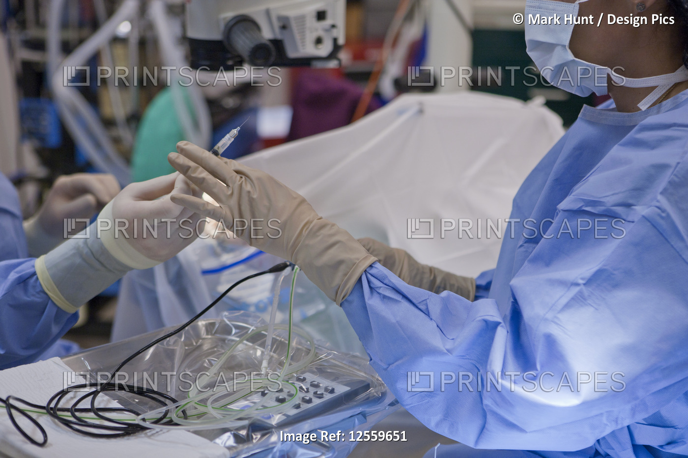 Doctor passing back syringe during cataract surgery