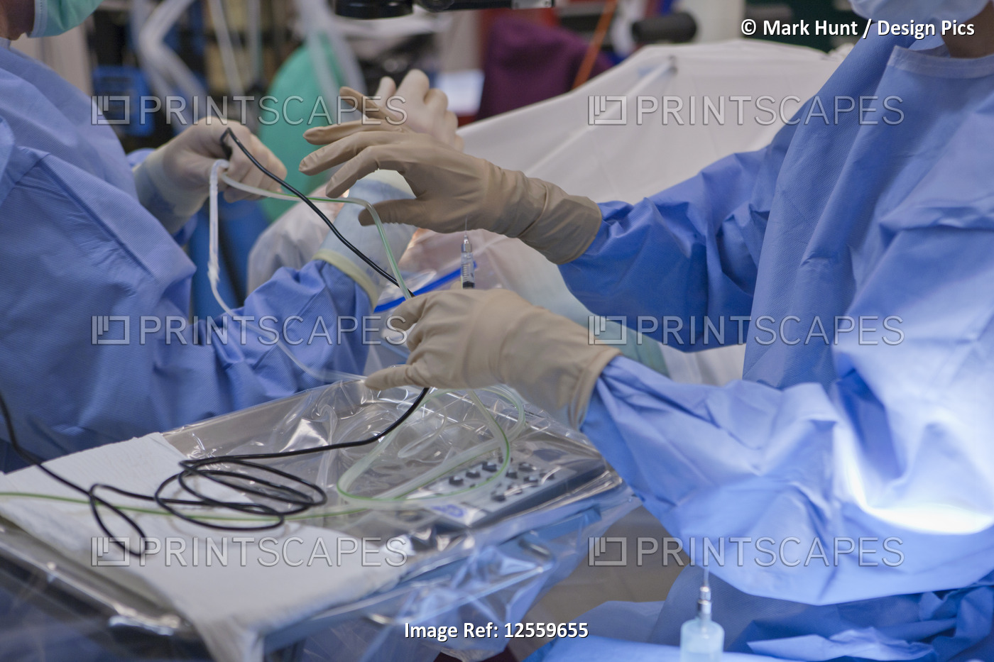 Surgical technologist passing a phaco hand piece to doctor during cataract ...