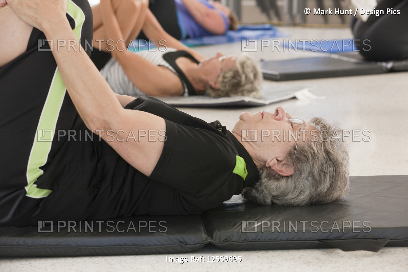 Seniors on floor mats doing let exercises