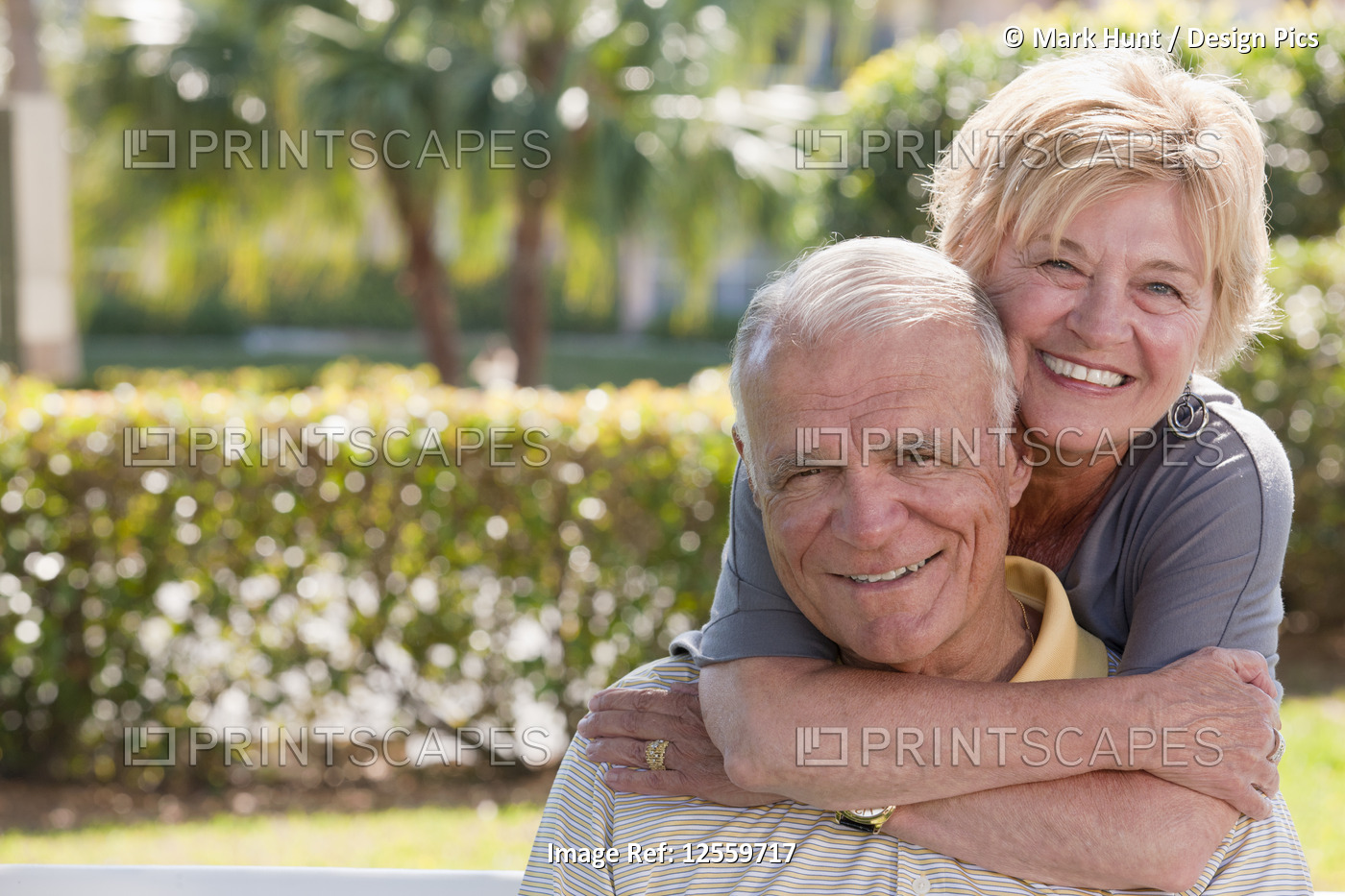 Portrait of a senior woman hugging a senior man from behind