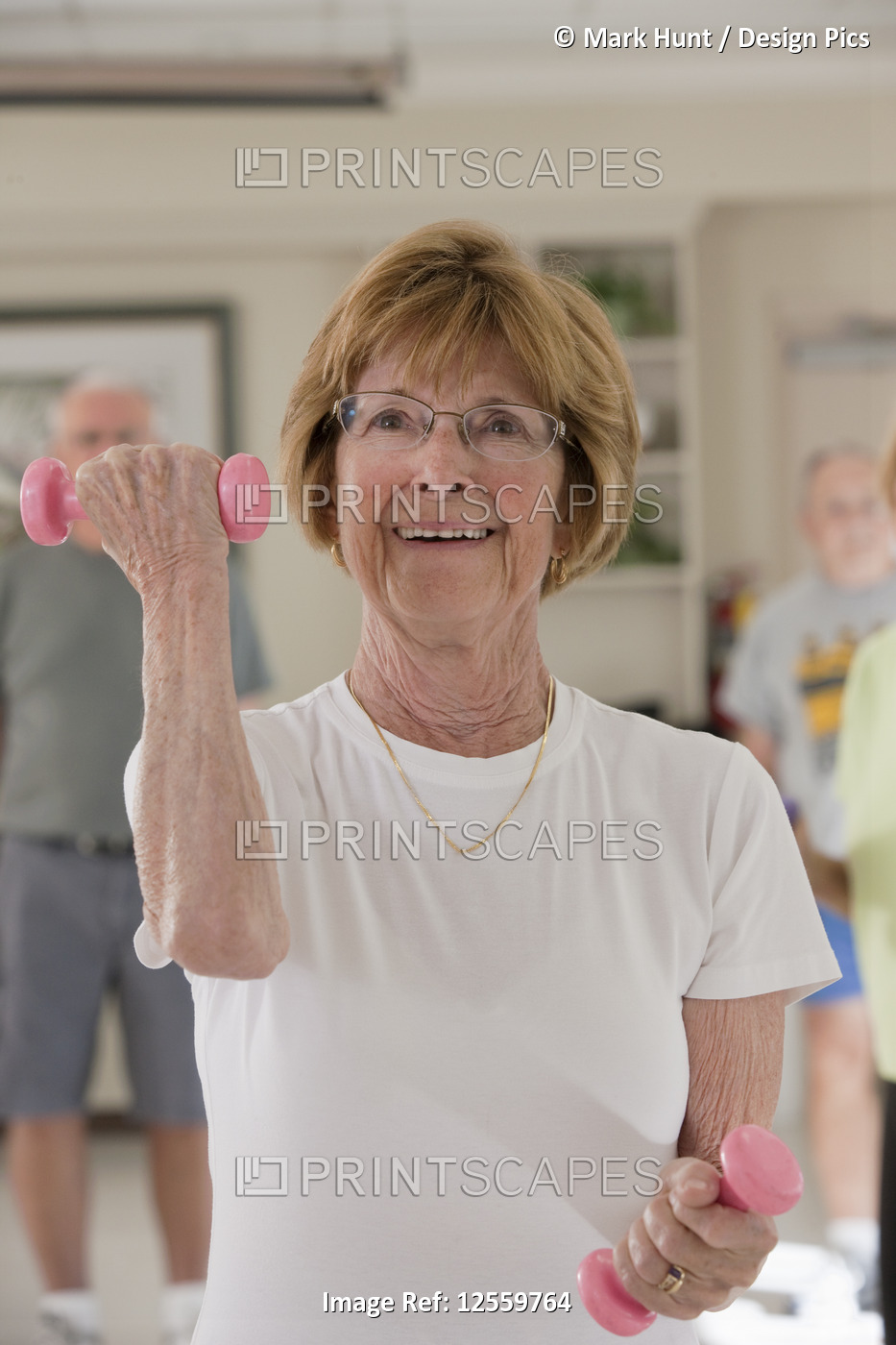 Senior woman exercising with dumbbells in a health club