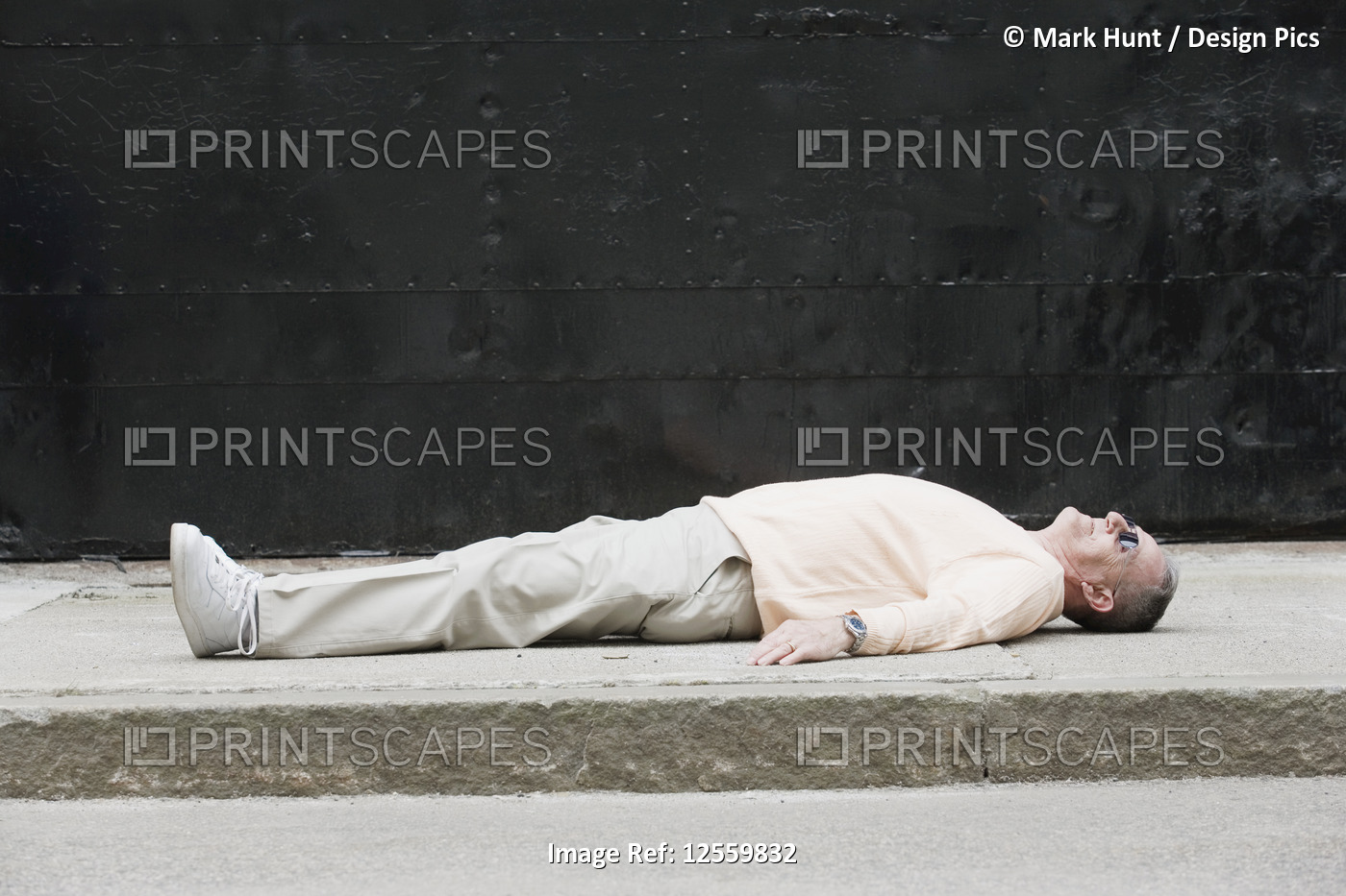 Senior man lying on a road.