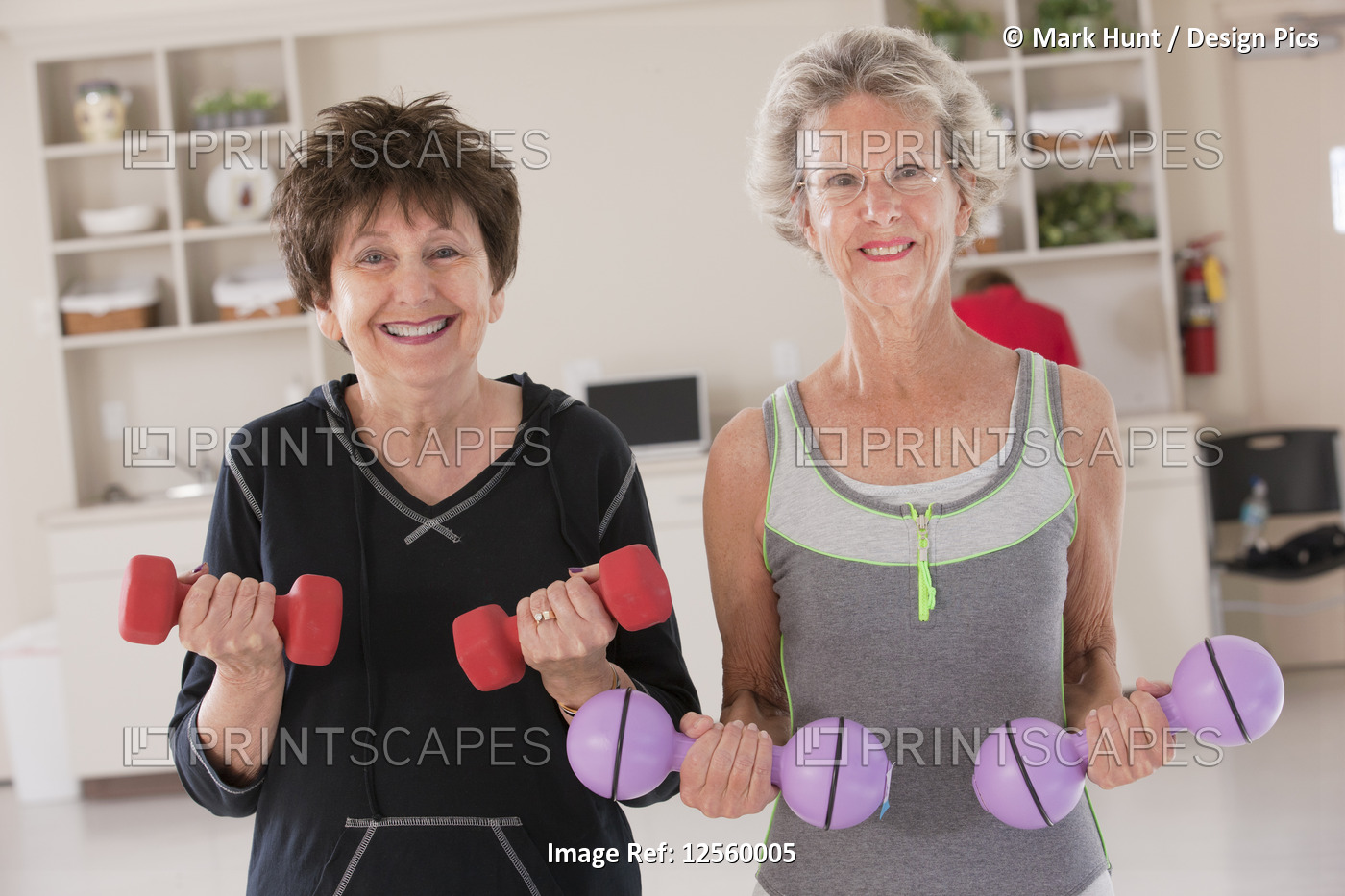 Portrait of two senior women exercising with dumbbells in a health club