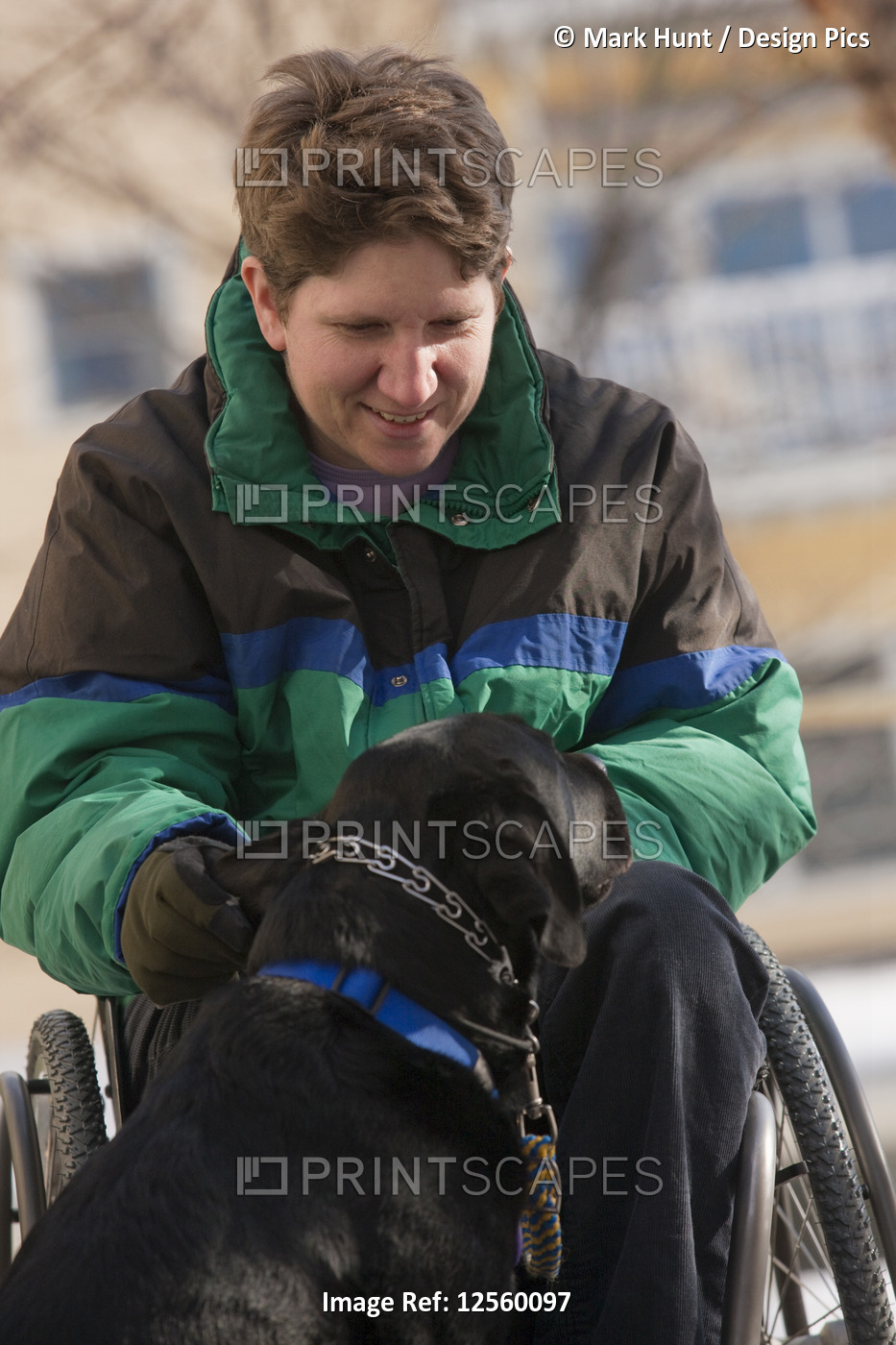 Woman with multiple sclerosis playing with a service dog in winter
