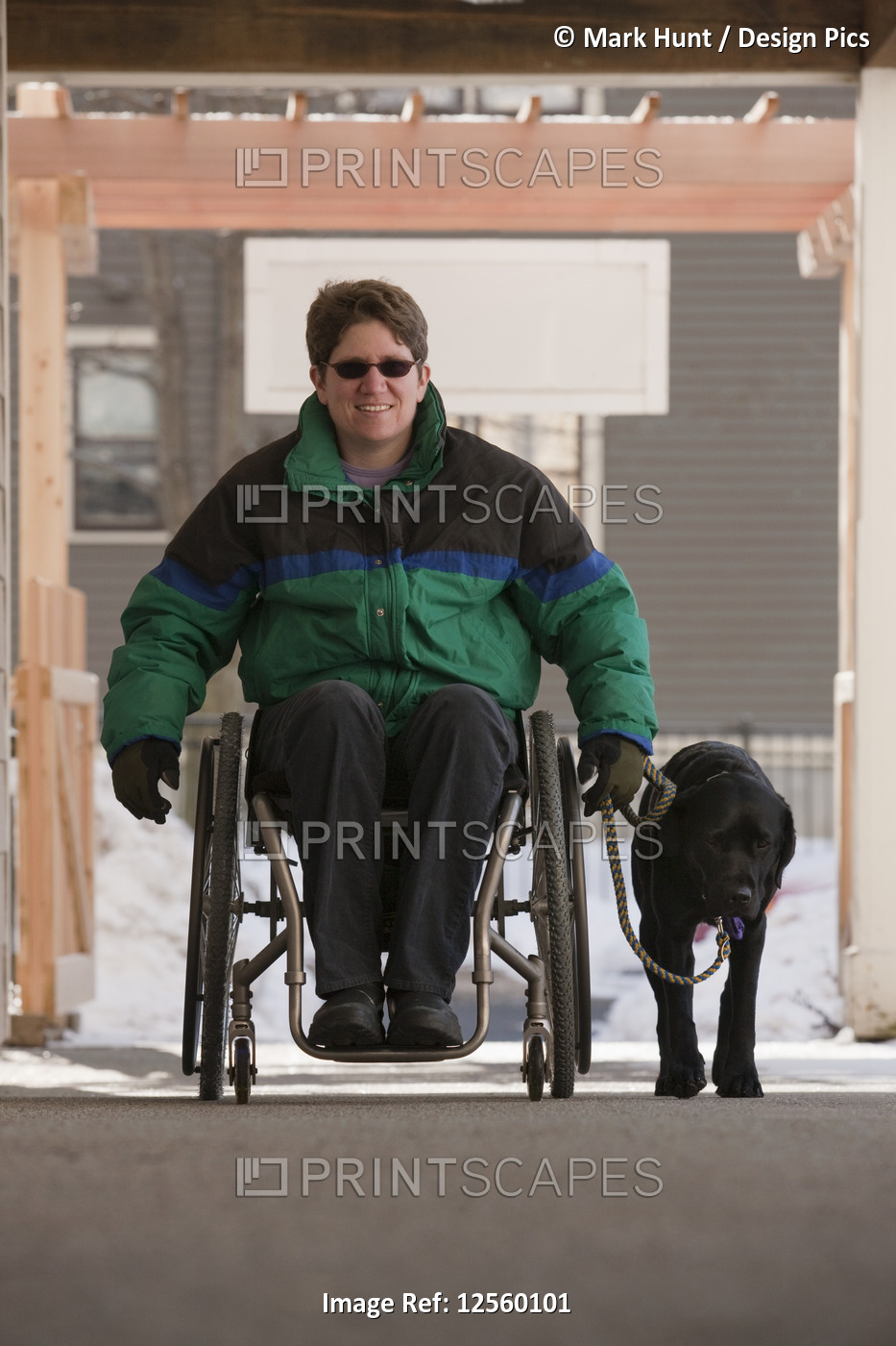 Woman with multiple sclerosis in a wheelchair with a service dog in winter