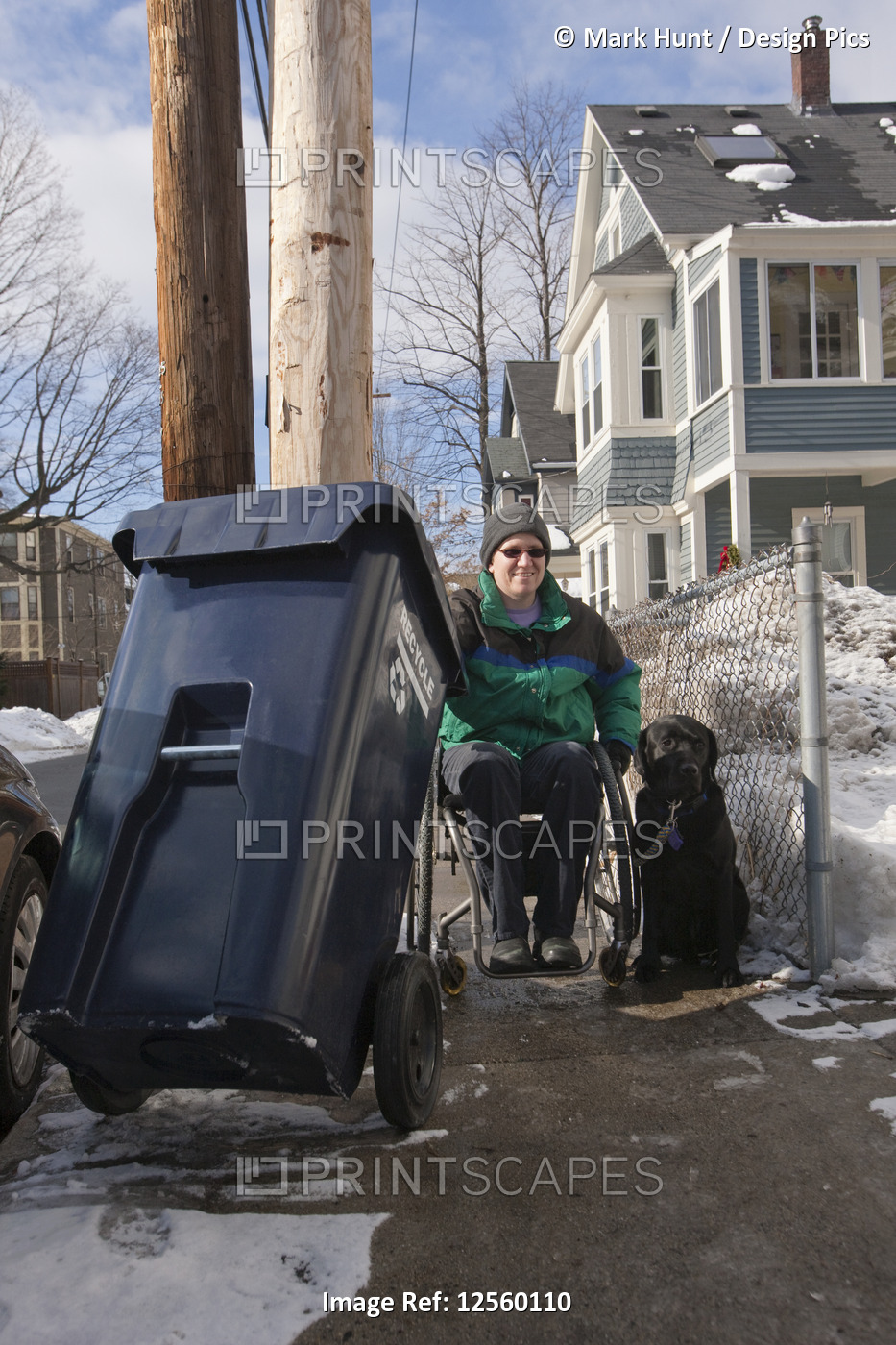 Woman with multiple sclerosis doing recycling with a service dog in winter