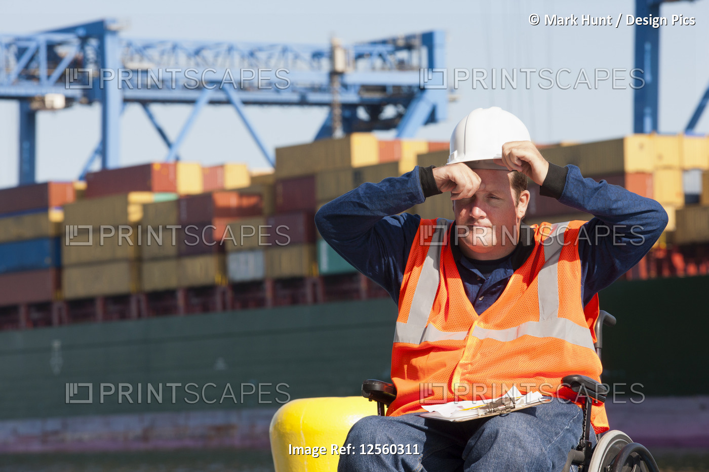 Transportation engineer in a wheelchair recording data for shipping containers ...