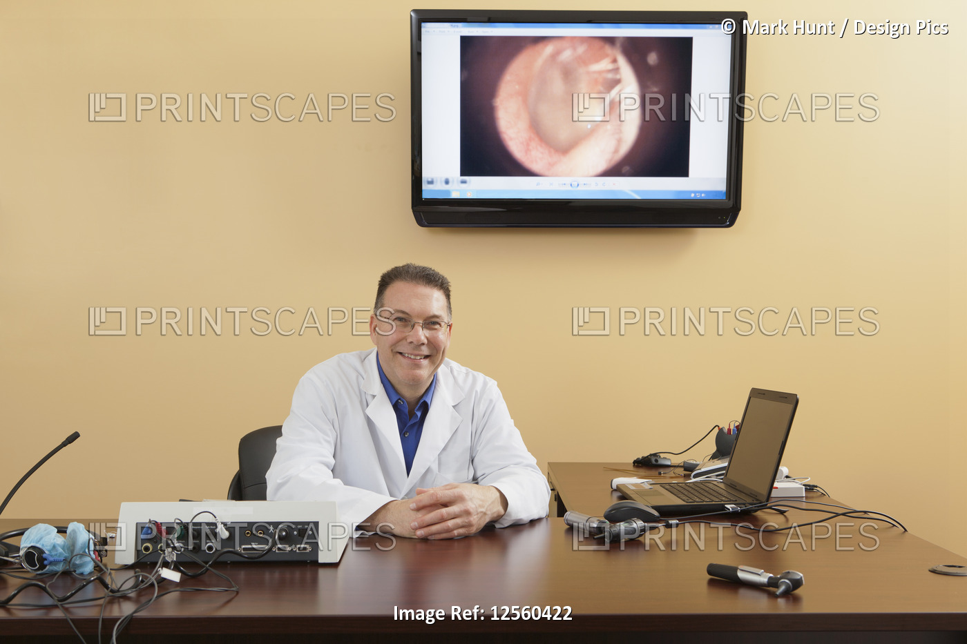 Portrait of an audiologist with his examination instruments and computer screen