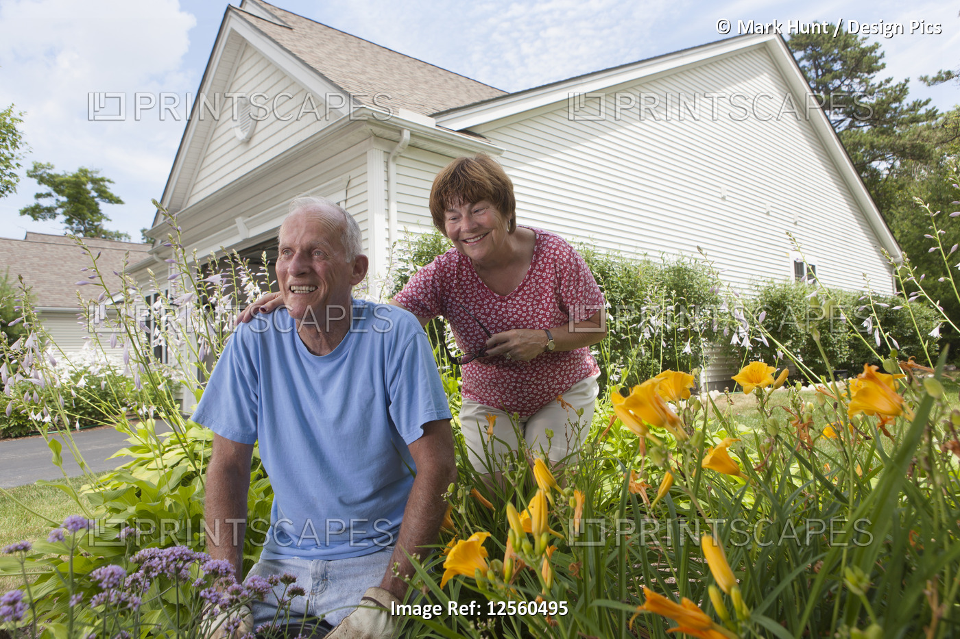 Senior couple preparing to plant flowers in garden