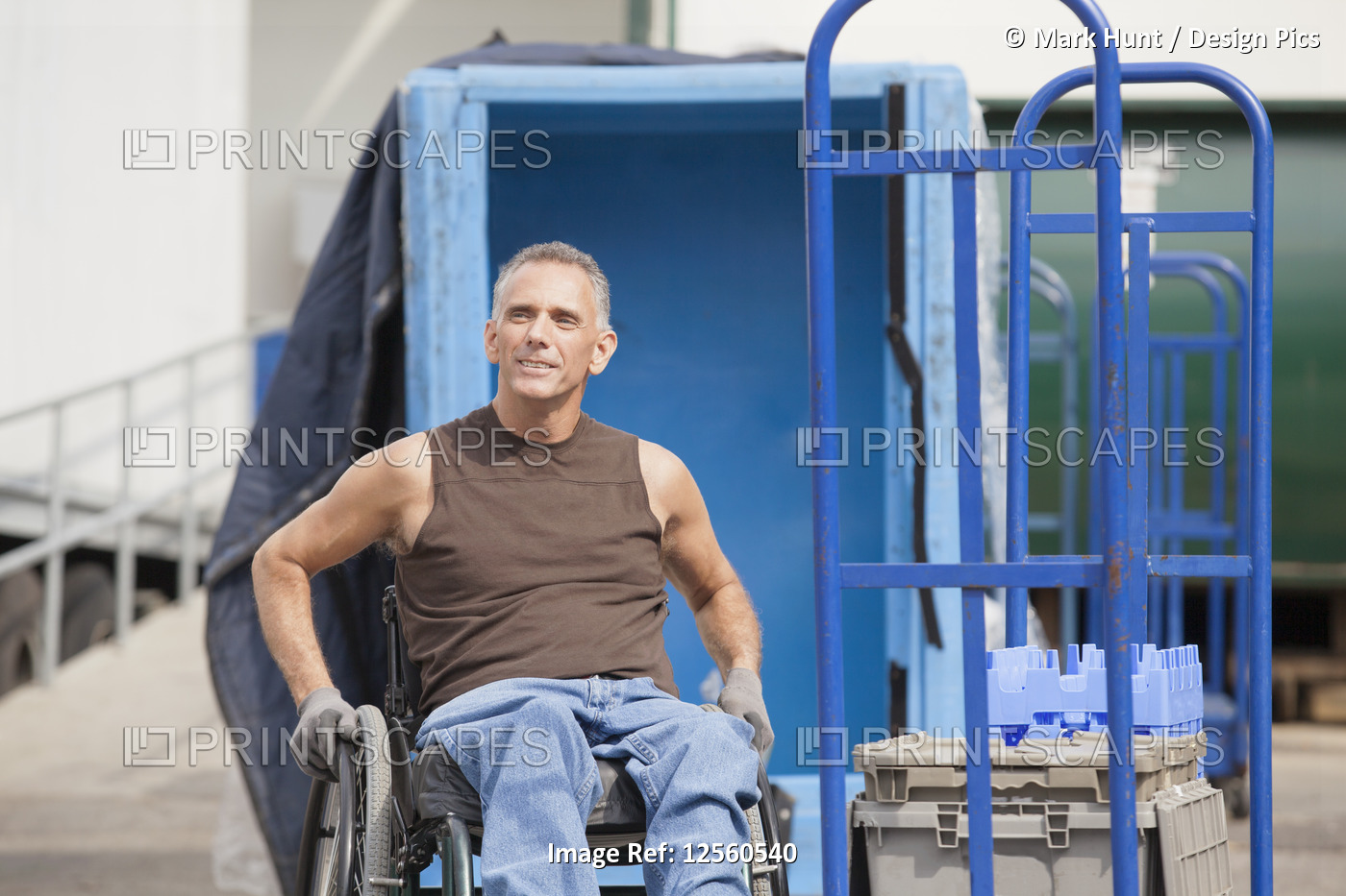 Loading dock worker with spinal cord injury in a wheelchair in storage area