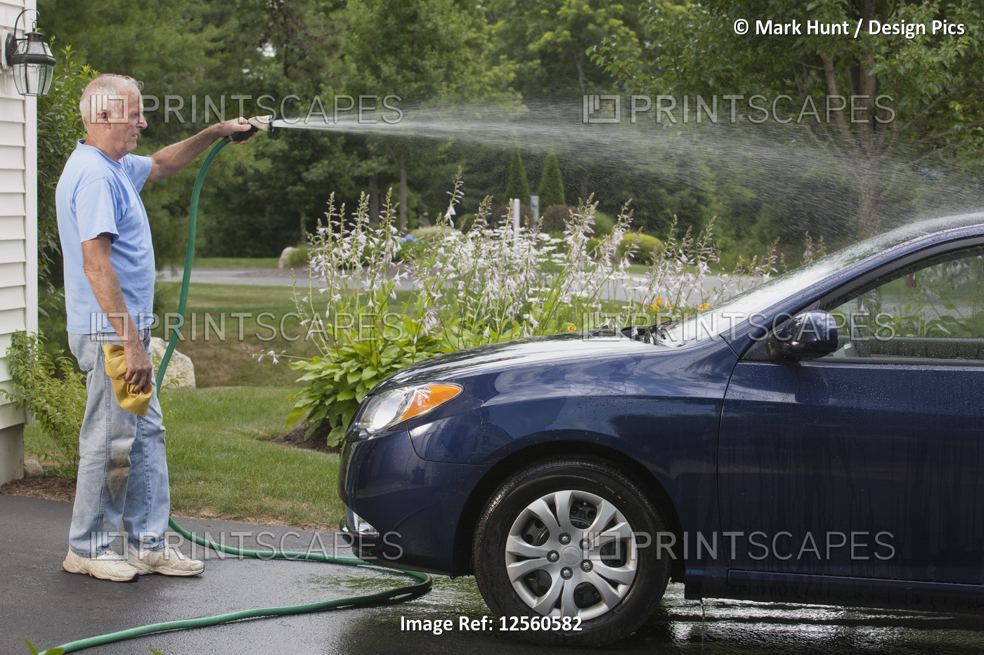 Senior man washing his car at home