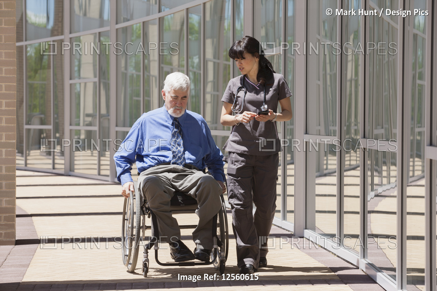 Man with muscular dystrophy and diabetes in his wheelchair walking with nurse ...