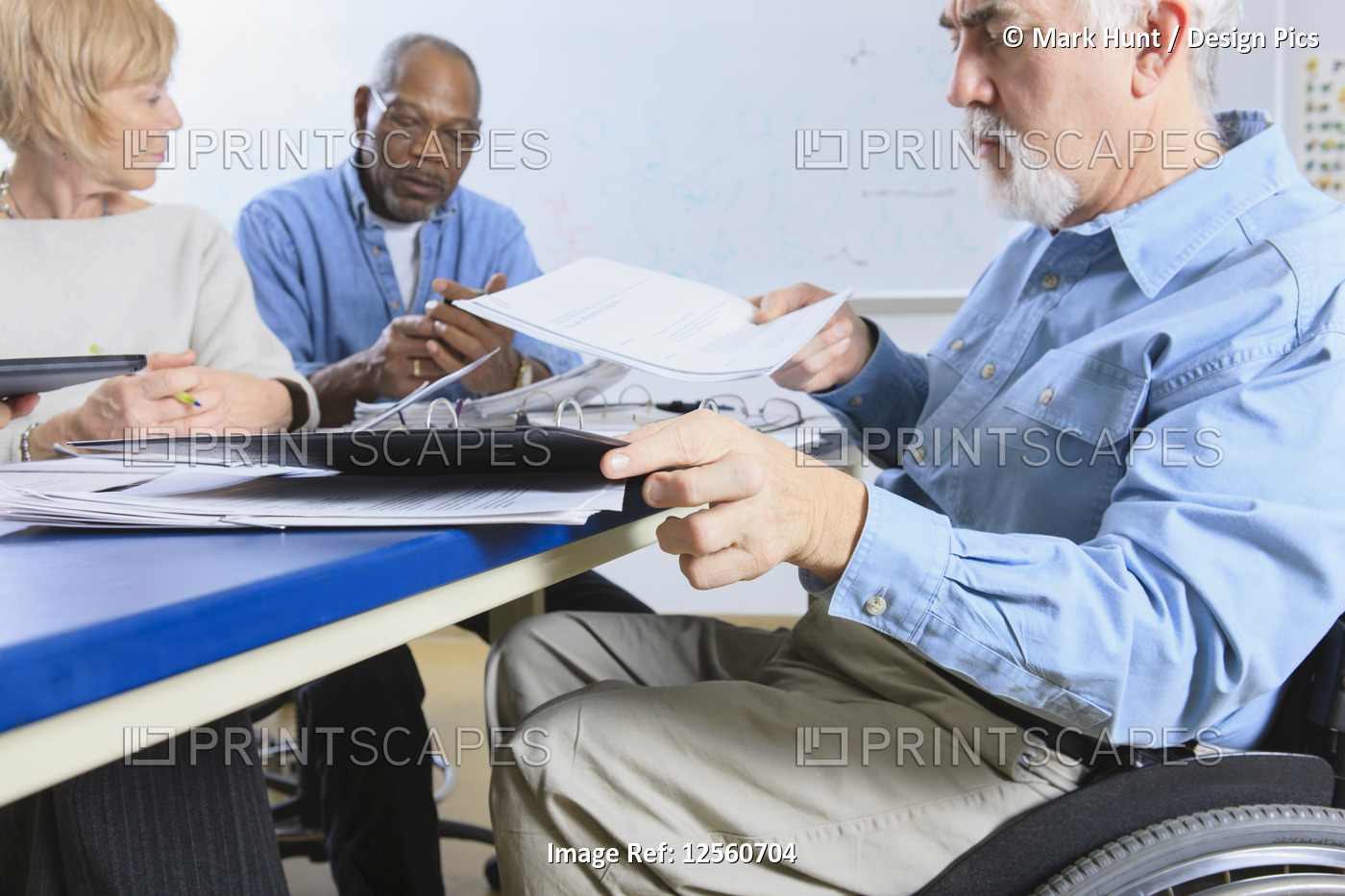 Professors in a faculty meeting, one in a wheelchair with Muscular Dystrophy