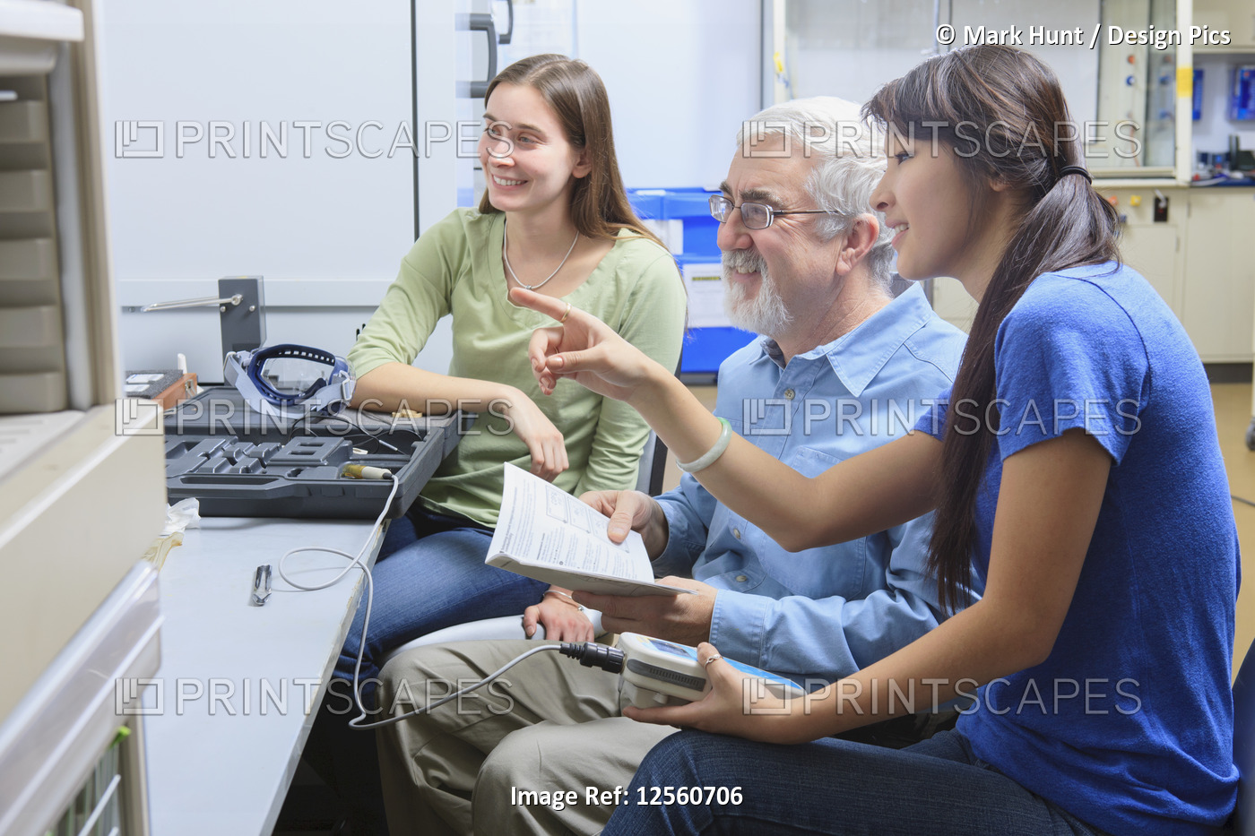 Professor working with students in a chemistry lab learning about ...
