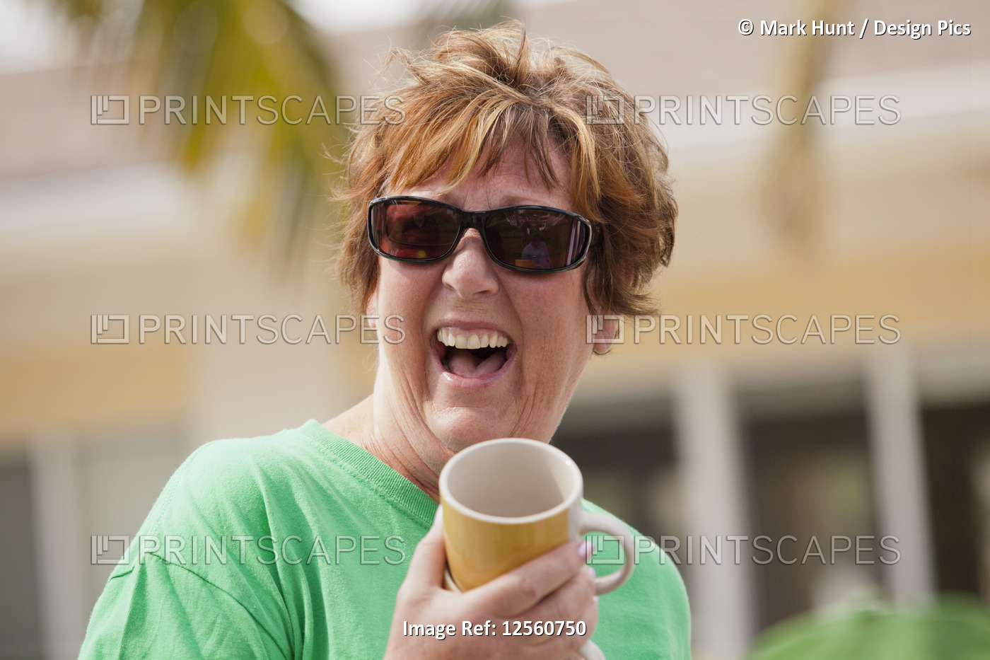 Senior woman holding a cup and laughing