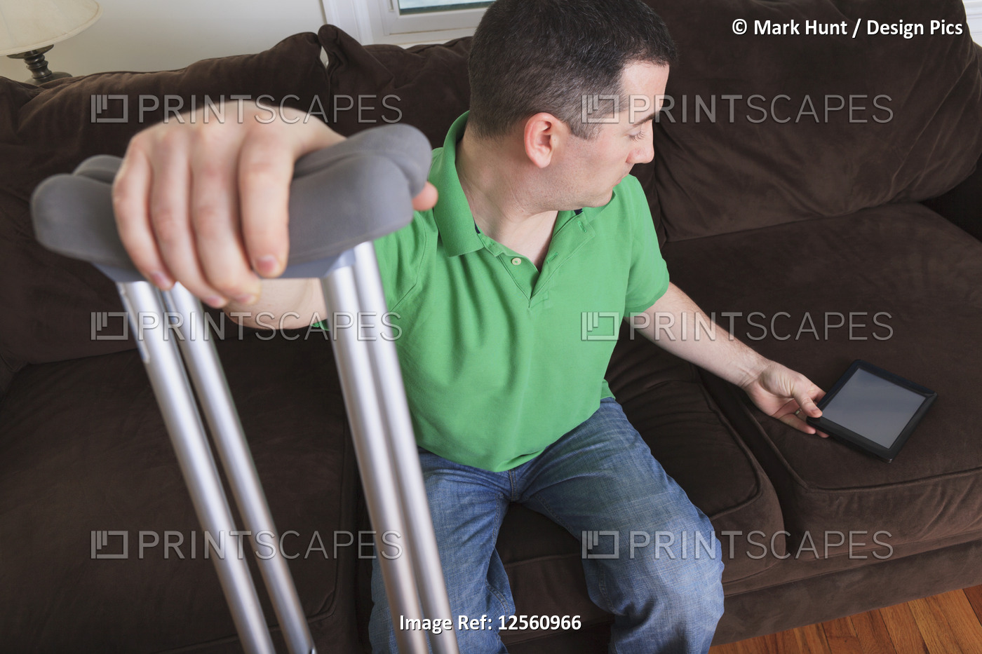 Man after anterior cruciate ligament (ACL) surgery with crutches and an digital ...