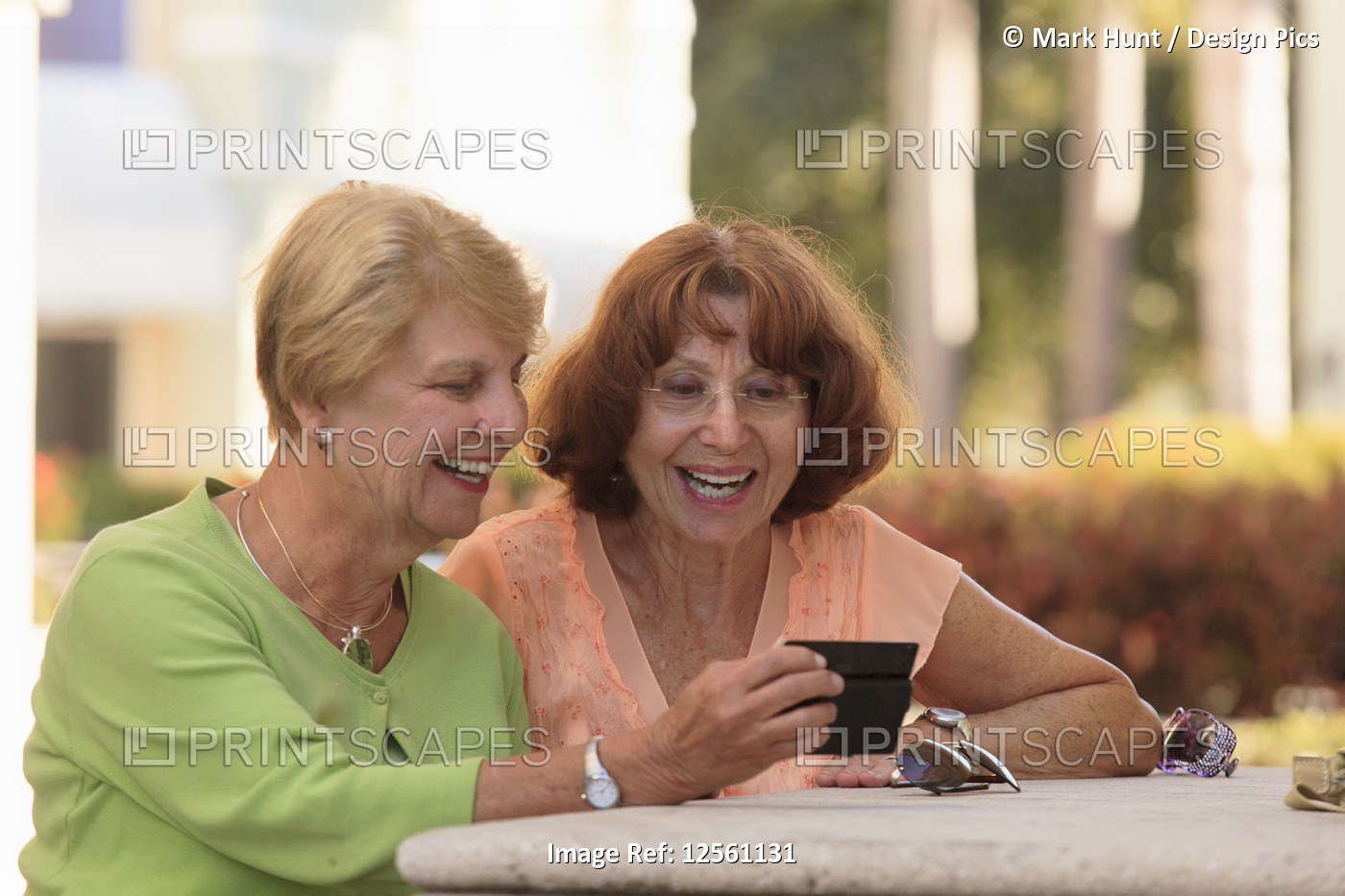 Senior friends looking at a smart phone and smiling