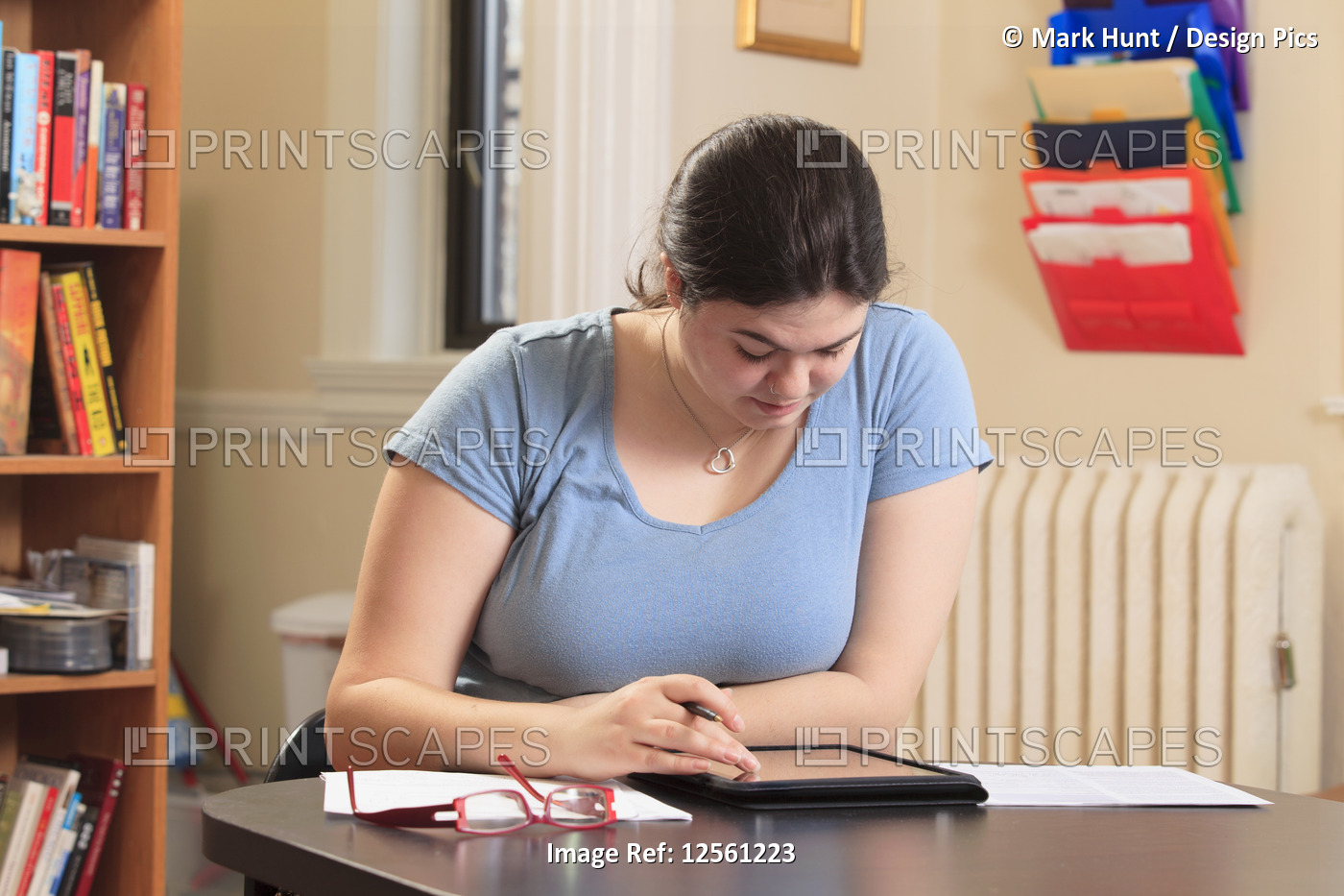 Woman with Asperger syndrome using her tablet to do work in home office