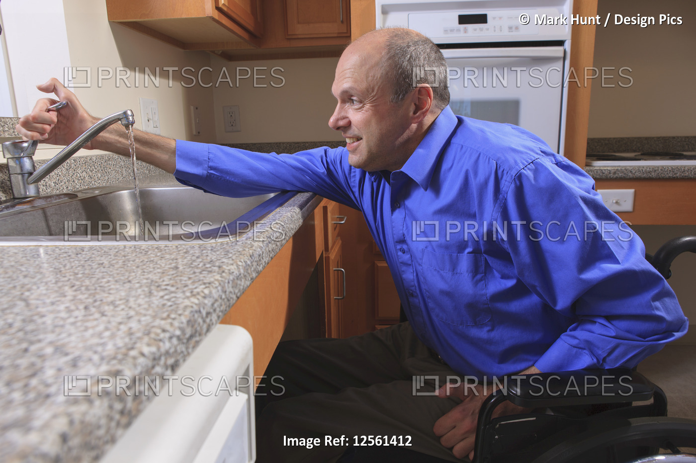 Man with Friedreich's Ataxia and deformed hands using his faucet in the kitchen