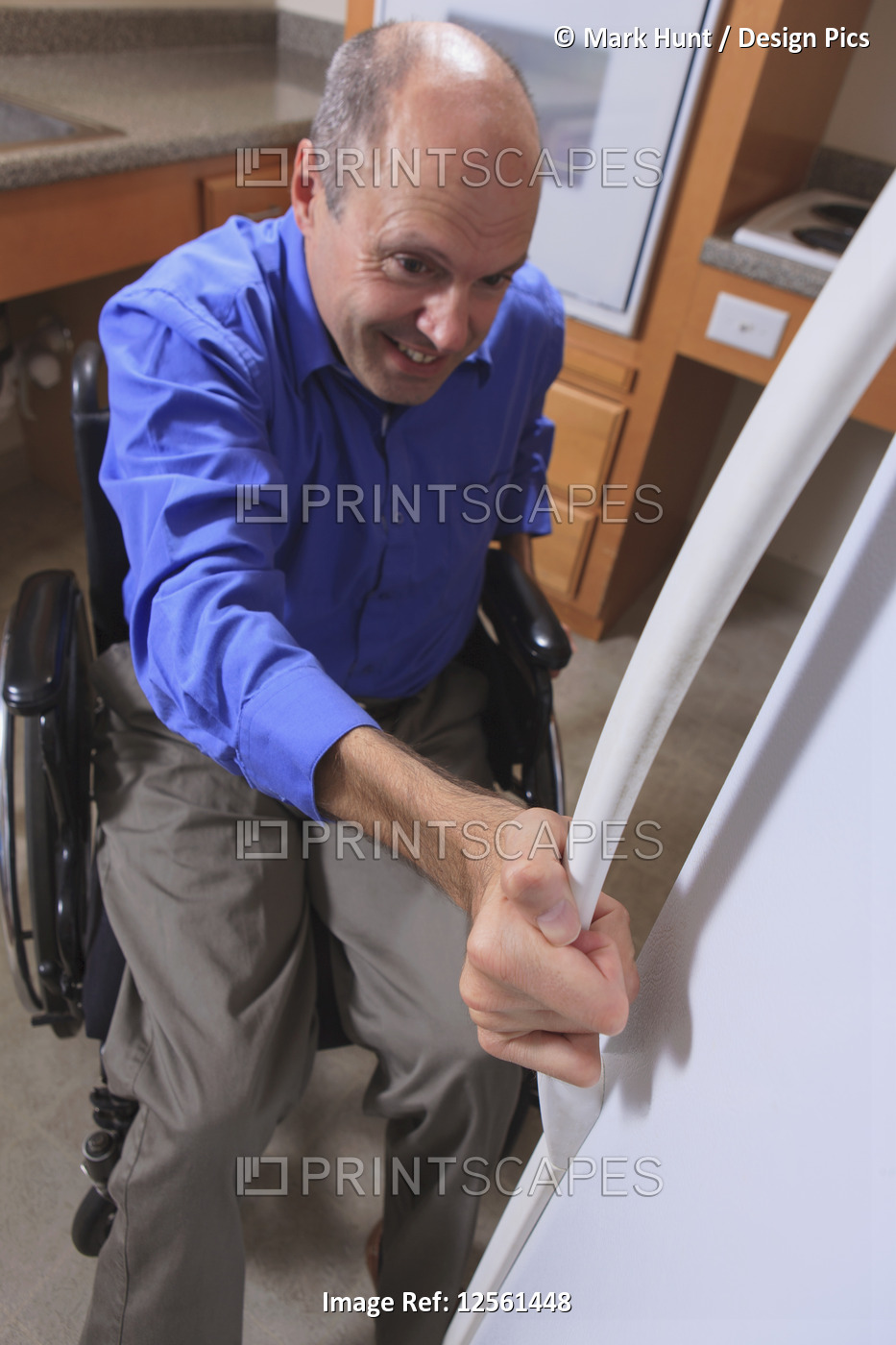 Man with Friedreich's Ataxia and deformed hands using his refrigerator