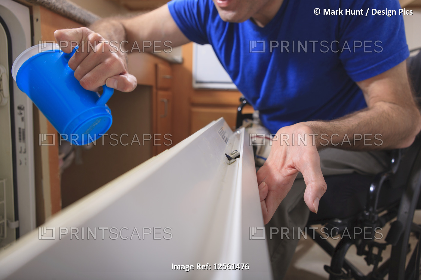 Man with Friedreich's Ataxia and deformed hands using his dishwasher