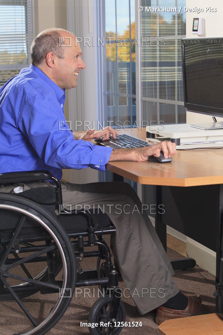 Man with Friedreich's Ataxia and deformed hands using his computer
