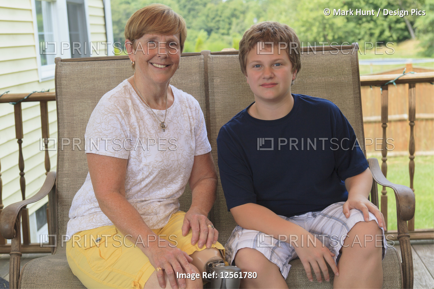 Grandmother with a prosthetic leg with her grandson sitting on their outdoor ...