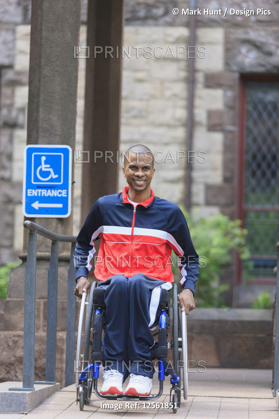 Man in wheelchair who had  Spinal Meningitis using a ramp